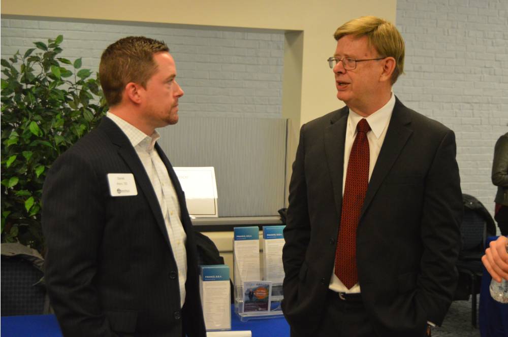 An alumnus and a faculty member converse with one another at the Academic Major Fair.